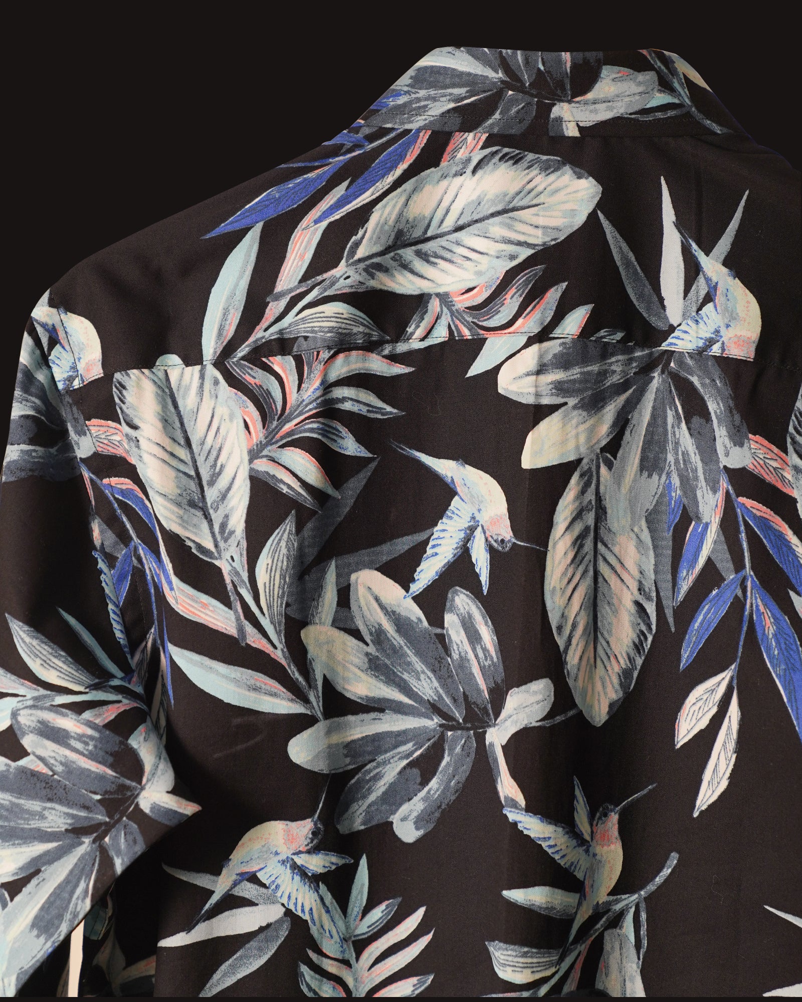 Black cotton shirt adorned with a striking tropical leaf print in shades of blue, grey, and subtle coral accents