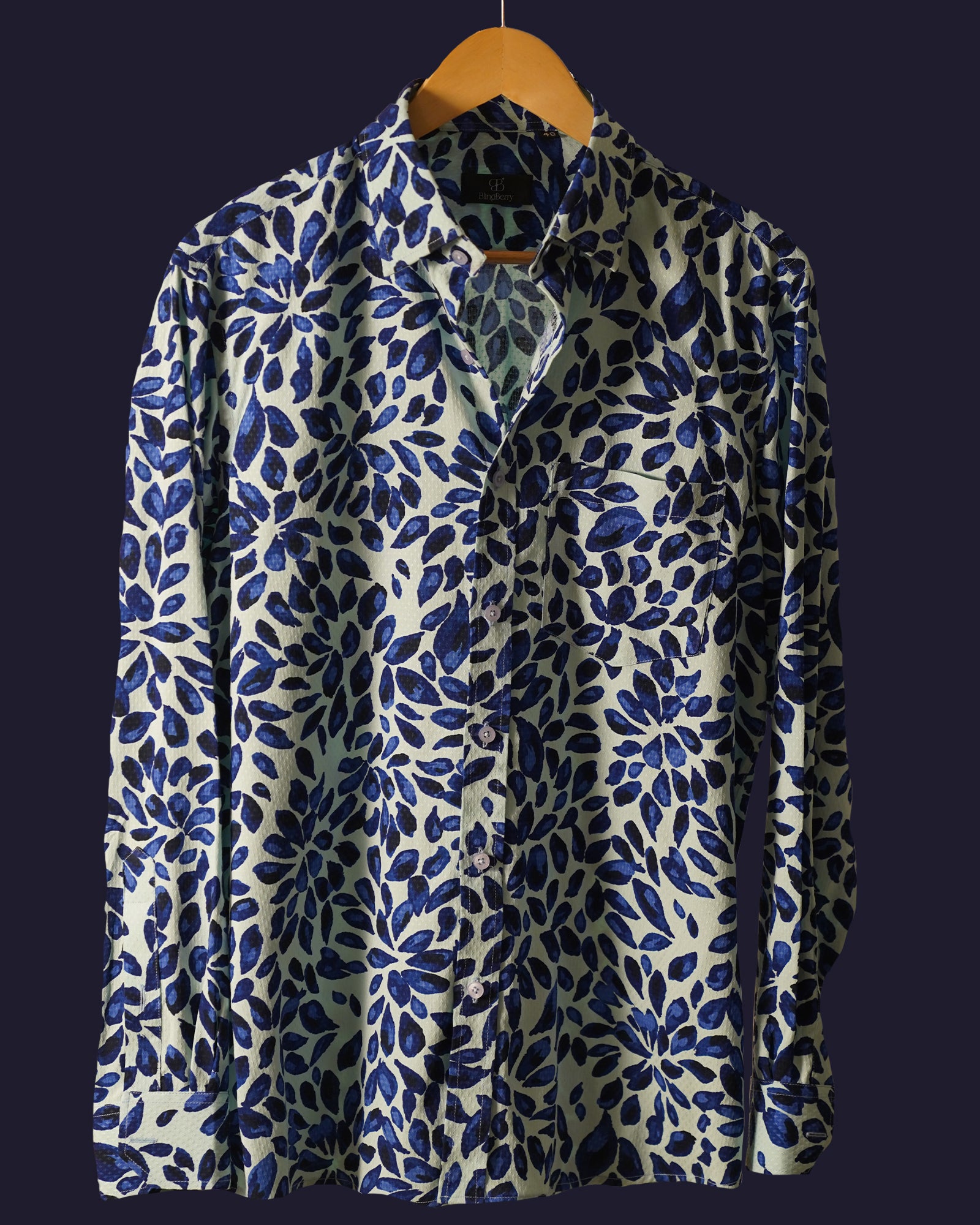 white cotton shirt featuring a bold abstract leaf print in deep blue tones