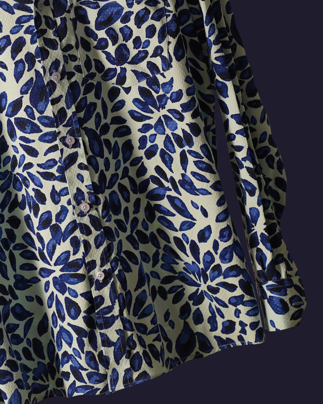 white cotton shirt featuring a bold abstract leaf print in deep blue tones