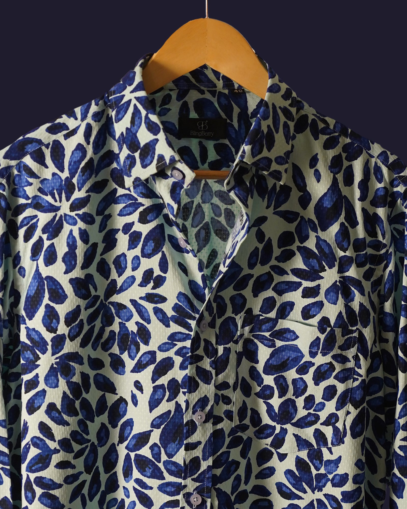 white cotton shirt featuring a bold abstract leaf print in deep blue tones