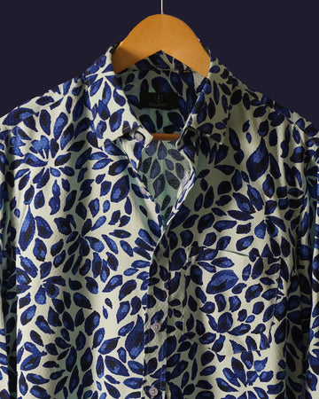 white cotton shirt featuring a bold abstract leaf print in deep blue tones