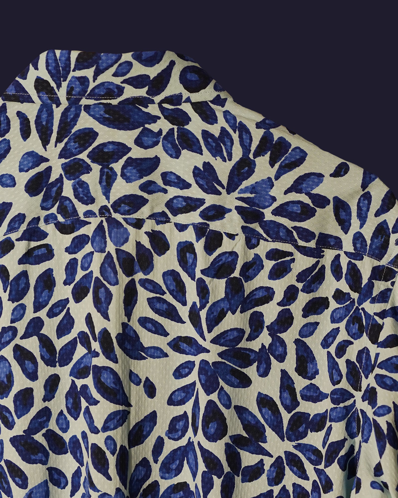 white cotton shirt featuring a bold abstract leaf print in deep blue tones